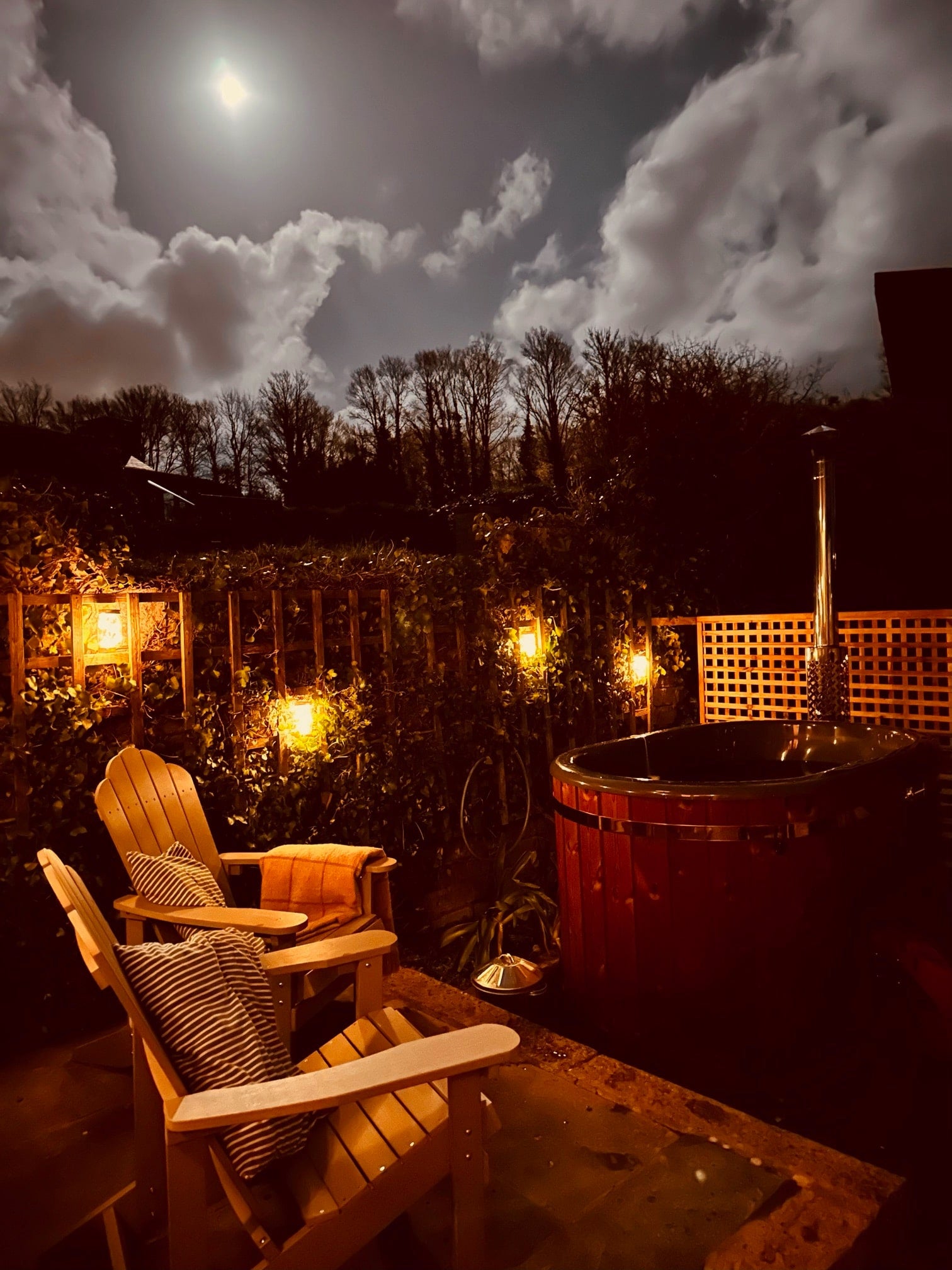 Gardenvity oval wood fired hot tub under moonlight surrounded by fairy lights