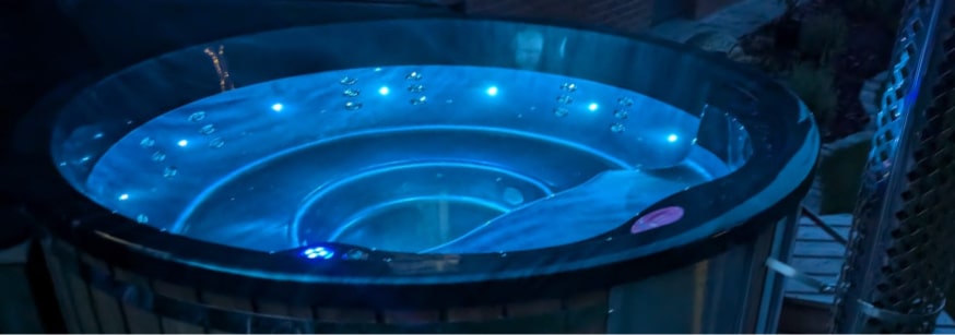 Blue LED lighting inside Gardenvity wood fired hot tub – evening relaxation setup